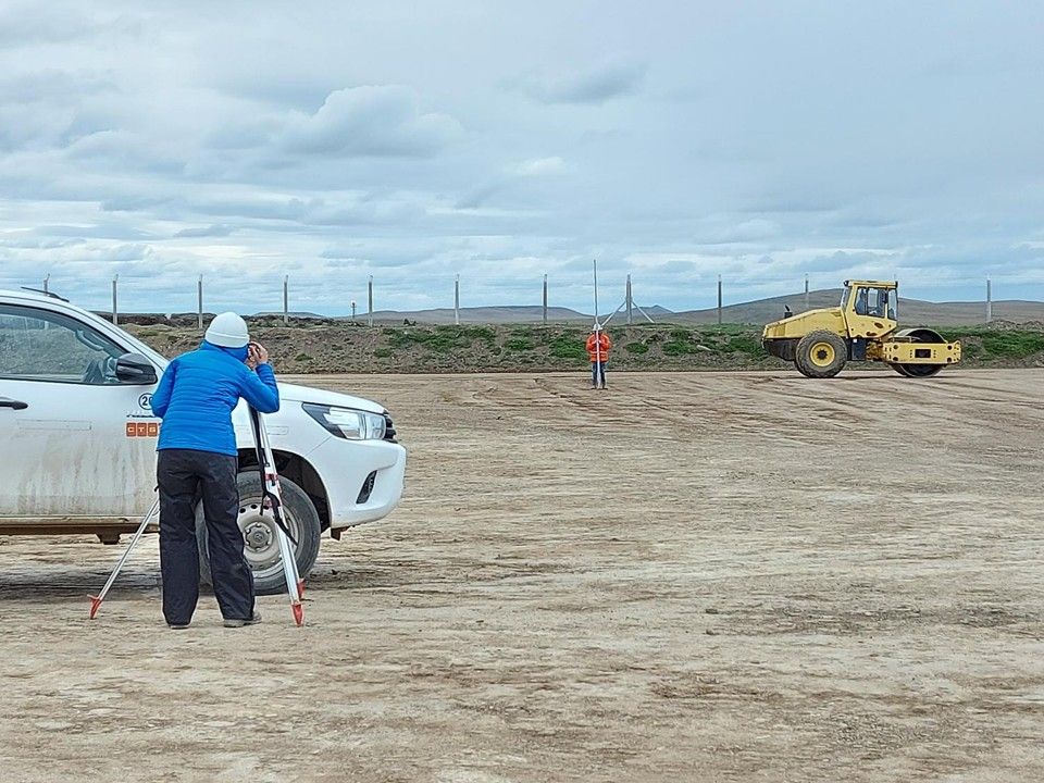 Relevamiento topográfico en obra con rodillo al fondo