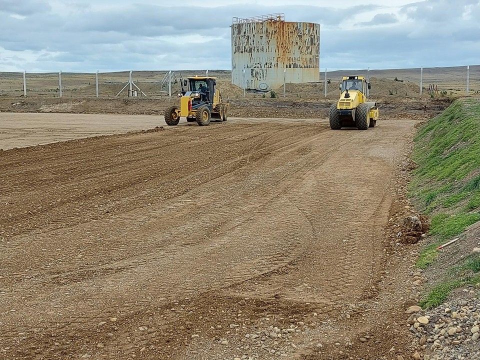 Cargadora y rodillo nivelando y compactando terreno
