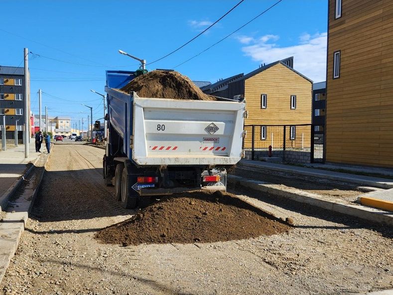 Camión volcador descargando material en obra urbana