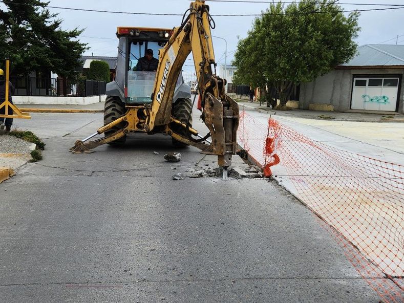 Retroexcavadora con martillo rompedor en la vía pública
